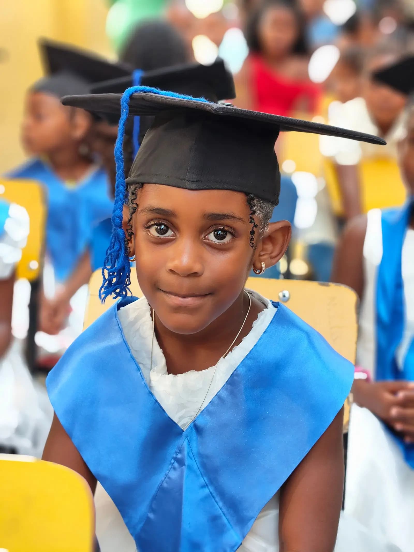 Proud pupil in a graduation cap and sash