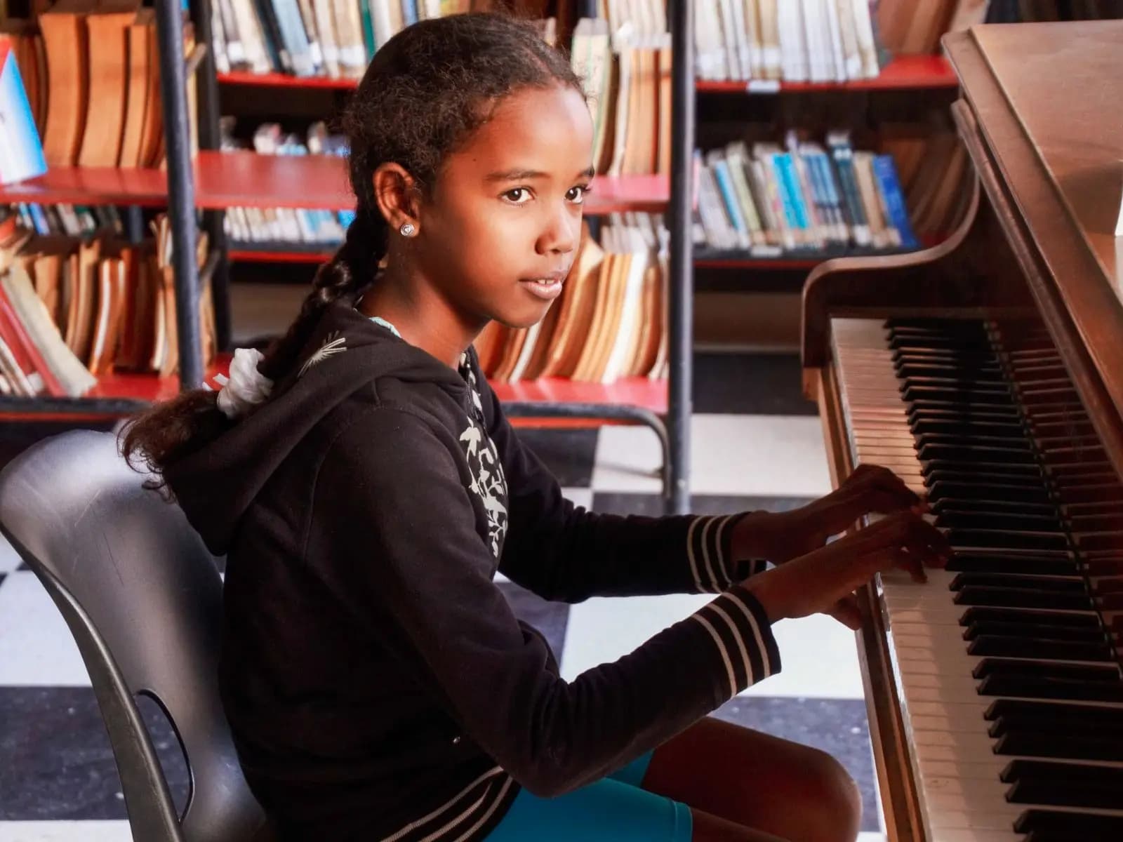 Pupil playing the piano in the music room