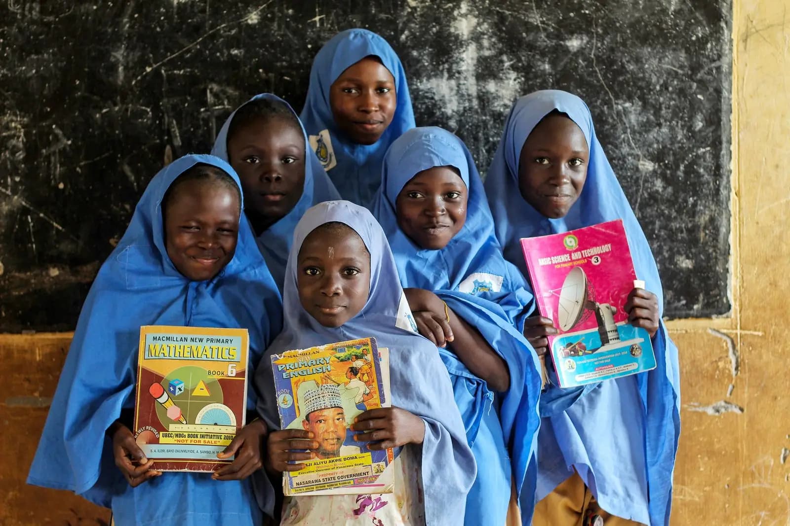 Pupils in blue hijabs holding their reading books