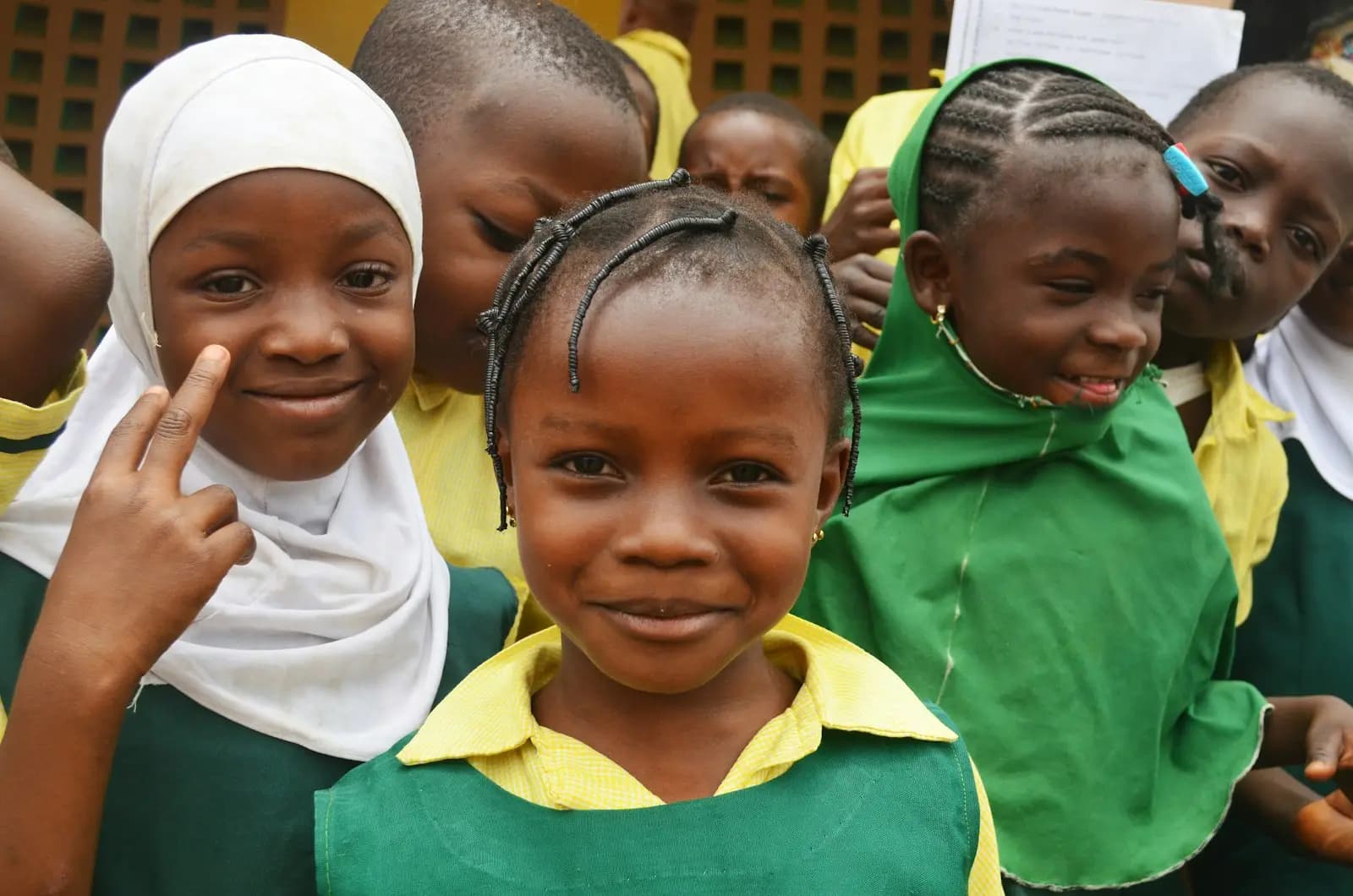 Smiling pupils in green and yellow school uniform